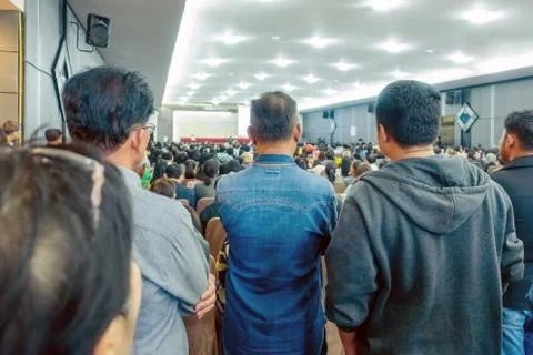Backside view of spectators standing in a gathering in the back of auditorium Stock Photos