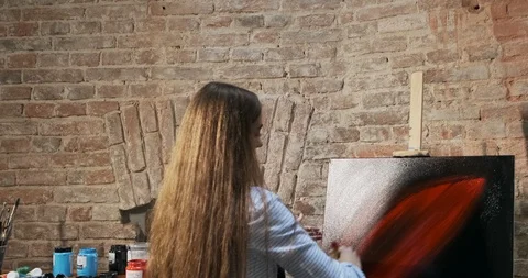 Backside view of talented innovative pretty female artist draws with brush on Stock Footage 122221641