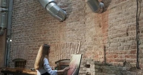 Backside view of talented innovative pretty female artist draws with brush on Stock Footage 122262016