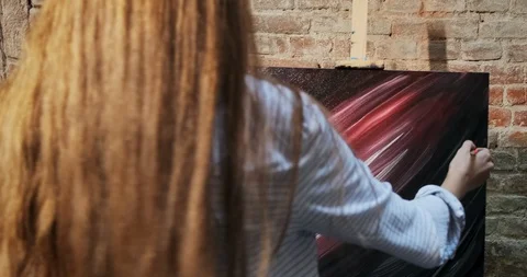 Backside view of talented innovative pretty female artist draws with brush on Stock Footage 123046542