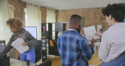 Backside view of two colleagues that discuss information in the documents in Stock Footage 112552950