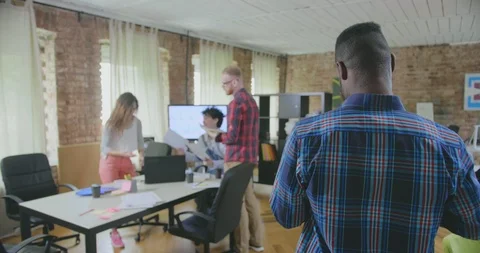 Backside view of young black man who walks to his workplace in modern office and Stock Footage 112553664