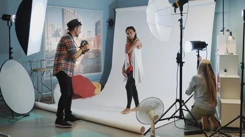 Backstage of the photo shoot: assistant adjusting the spotlight Stock Footage 122585495