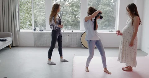 Backstage of the photo shoot:  Photographer  taking photo of a caucasian pregnan Stock Footage 113072353