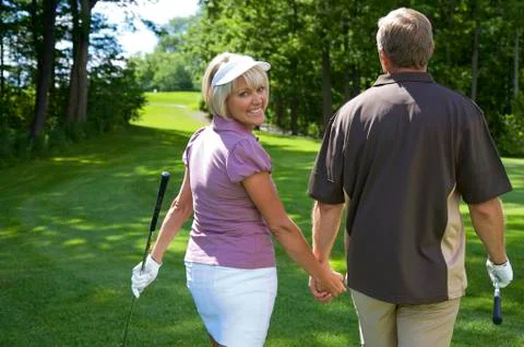 Backview of Couple Walking on Golf Course Fotos de archivo