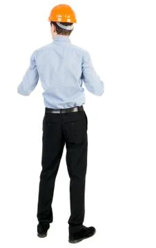 Backview of an engineer in construction helmet stands Stock Photos