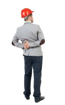 Backview of an engineer in construction helmet stands Stock-Fotos