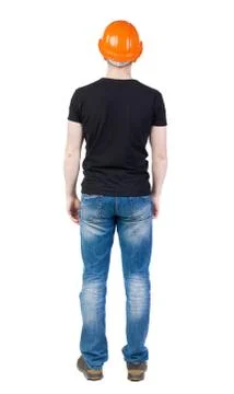 Backview of an engineer in construction helmet stands Stock-Fotos