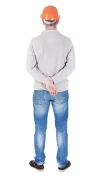 Backview of an engineer in construction helmet stands Stock-Fotos