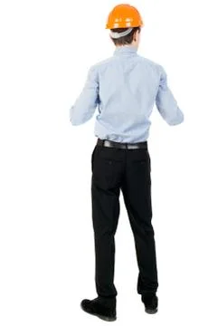 Backview of an engineer in construction helmet stands Stock Photos