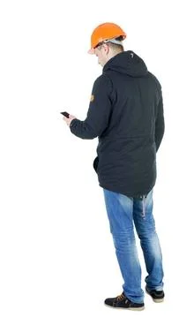 Backview of an engineer in construction helmet stands and using Backview o... 写真素材