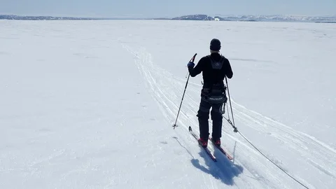 Backview of explorer skiing though Greenland glacier with pulka. 스톡 동영상 129510804