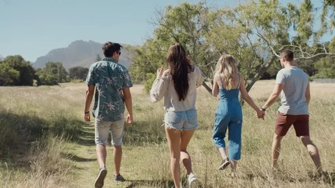 Backview of friends walking outdoors having fun Stock Footage 93324926