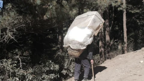 Backview of Porter with rain cover protecting the load on the way up to Namche. 스톡 동영상 236774008