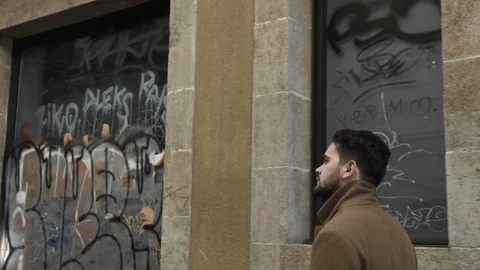 Backview tracking shot of young hipster man walking through narrow city streets Stock Footage 106727242