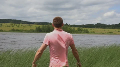Backview of young man on river bank rising hands lifestyle consept Stock-Footage 155172516
