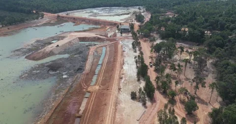 Backward aerial: construction site, muddy paths, ponds, forest, dump truck 스톡 동영상 338046095