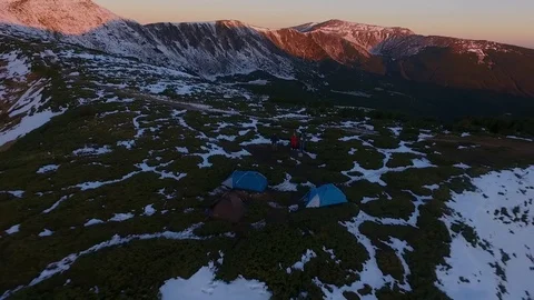 Backward aerial top view over winter snowy mountain and woods forest at sunset 動画素材 101030531
