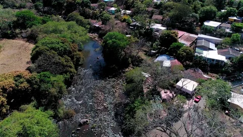 Backward drone flight over buildings next to a river in Central America 02 Stock Footage 101311342