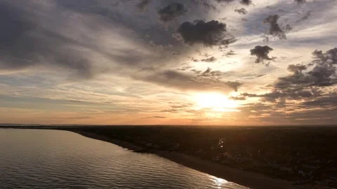 Backward Drone Flight Over Coast At Golden Sunset With Dramatic Clouds Stock Footage 341865411