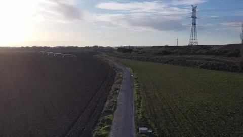 Backward Drone Flight Over Rural Road Between Green and Plowed Fields Stock Footage 325223160