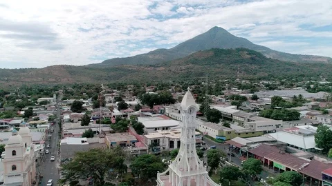 Backward drone flight over a small town and volcanic landscape Stock Footage 101475497