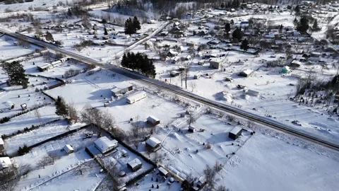 Backward Drone Flight Over Snow-Covered Rural Homes and Winter Landscape Stock Footage 339489964