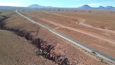 Backward drone flight revealing a vast desert highway running alongside a 库存影片 333441520