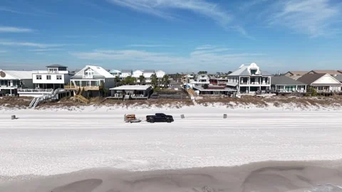 Backward drone fly from the beachfront houses with new empty lot along sandy Stock-Footage 332078310