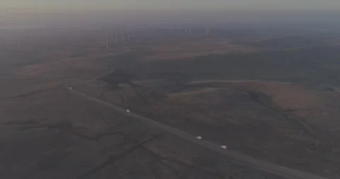 Backward Drone Pull Away from Cars Driving Toward Wind Farm, Russia Vídeo Stock 344035286