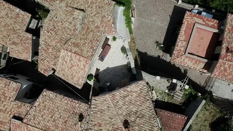 Backward flight to above - A small square of a medieval village perched on rock Stock Footage 92467822
