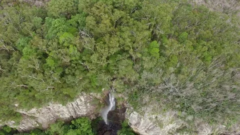 Backward flight with camera tilt revealing magnificent tall waterfall and rug Stock Footage 88979493