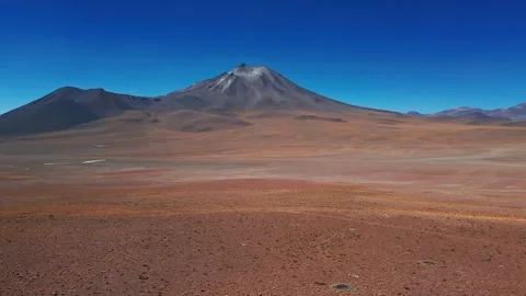Backward flight distancing from dramatic isolated volcanic cone rising over Stock Footage 336265990