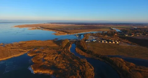 Backward flight over the ice covered lagoon from countryside Dreverna (LTU) Stock-Footage 101552178