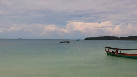 Backward flying drone over a blonde girl standing in the sea with clothes Stock Footage 111394989