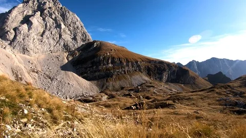 Backward moving behind tall grass with Mangart mountain in Julian Alps Stock Footage 122211359