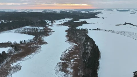 Backward panorama drone fly of winter wetlands winding through wide snowy Vidéo 331610932