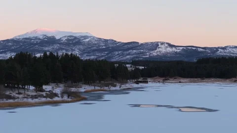 Backward panoramic drone movement at Laguna La Zeta with snowy lake shore with Stock Footage 313480713