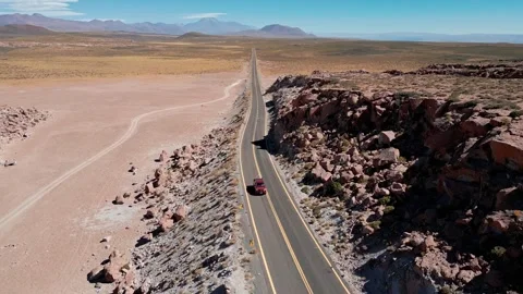 Backward tracking shot following pickup truck exiting red rock canyon onto vast Stock Footage 336266228
