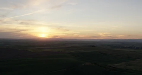 Backward tracking shot of sun setting over field, helicopter aerial, drone Stock Footage 115342928