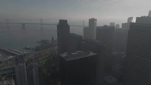 Backward tracking wide shot with buildings foreground and SF bridge background Vídeos de archivo 336793219