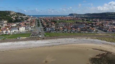 Backwards drone flight over british seaside town to revale beach Video stock 126981434