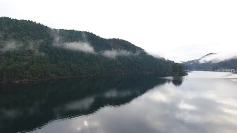 Backwards drone flight over lake lifts up to reveal vast scenery Video stock 126981832