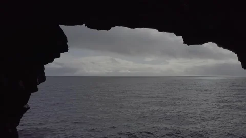 Backwards drone shot through cave next to the see in Iceland. 動画素材 143830250