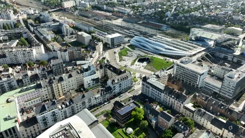 Backwards drone tilt shot of the new Rennes station between high-rise Stock Footage 253762500