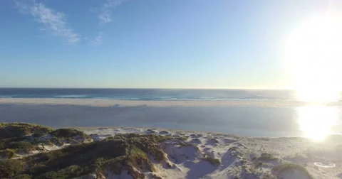 Backwards flight from the beach over grassy sand dunes. Cape Town, South Africa  Stock-Footage 65804780
