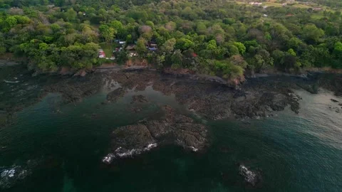 Backwards flight on rocky coast line revealing cinematic ocean view Stock Footage 262661317