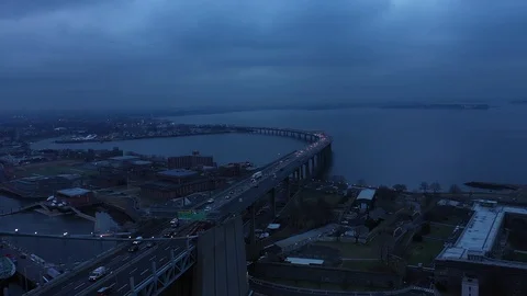 Backwards flying reveal of Bridge arch cloudy at dusk Stock Footage