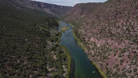 Backwards Moving Aerial view of green river in Utah with fishing boat Stock Footage 276415427