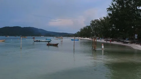 Backwards moving drone view of island coast and a little girl local walking at c Stock Footage 111285375